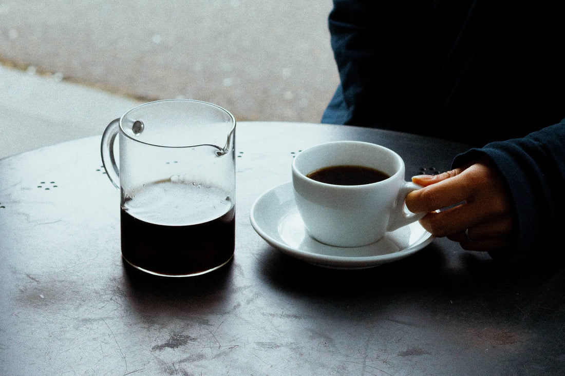 Evening coffee: a carafe and a small cup of decaf on a dark table