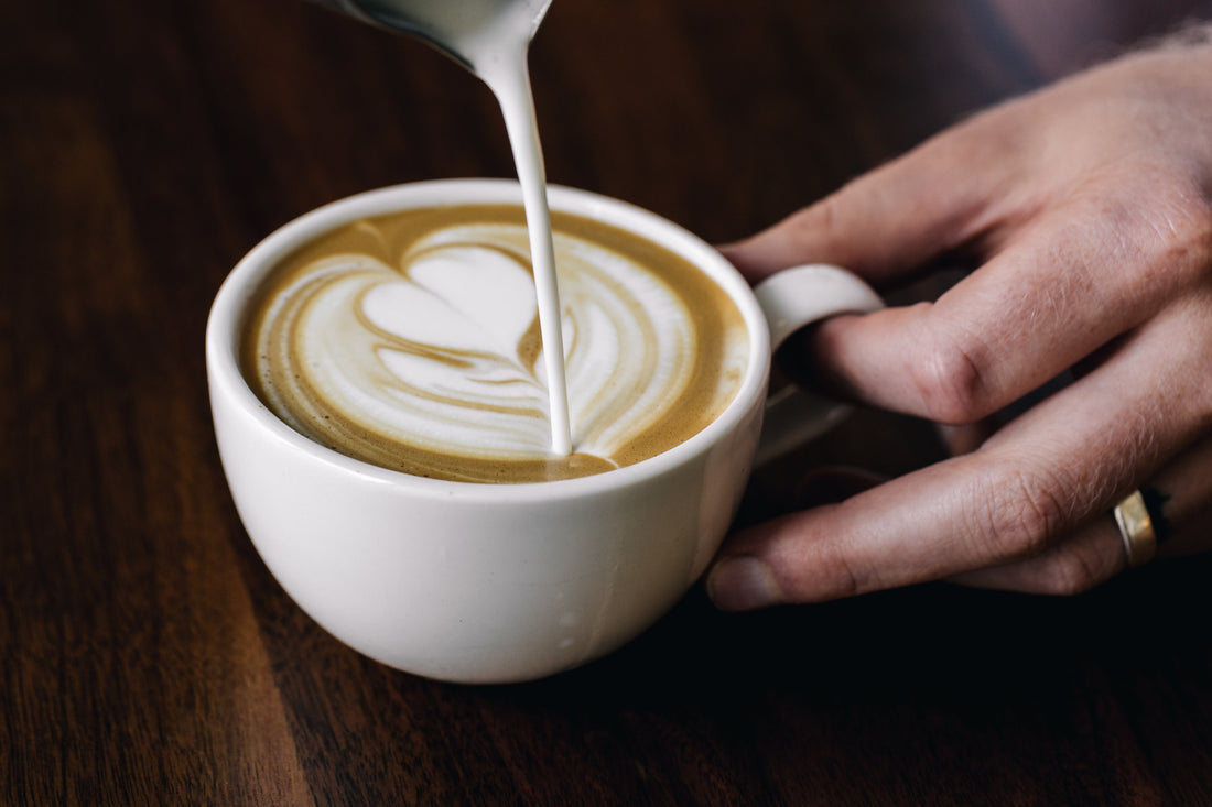 Pouring steamed milk into a latte made with The Resident